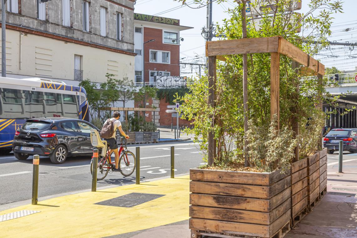 Image de la rue Faubourg Bonnefoy avec une jardinière et un cycliste