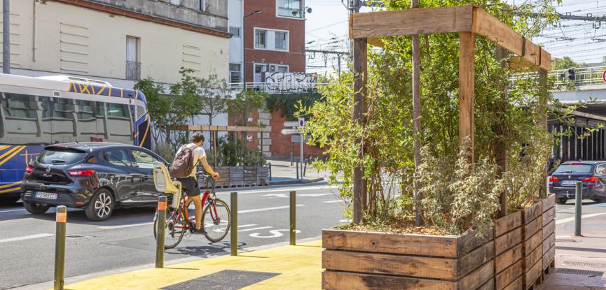 Image de la rue Faubourg Bonnefoy avec une jardinière et un cycliste